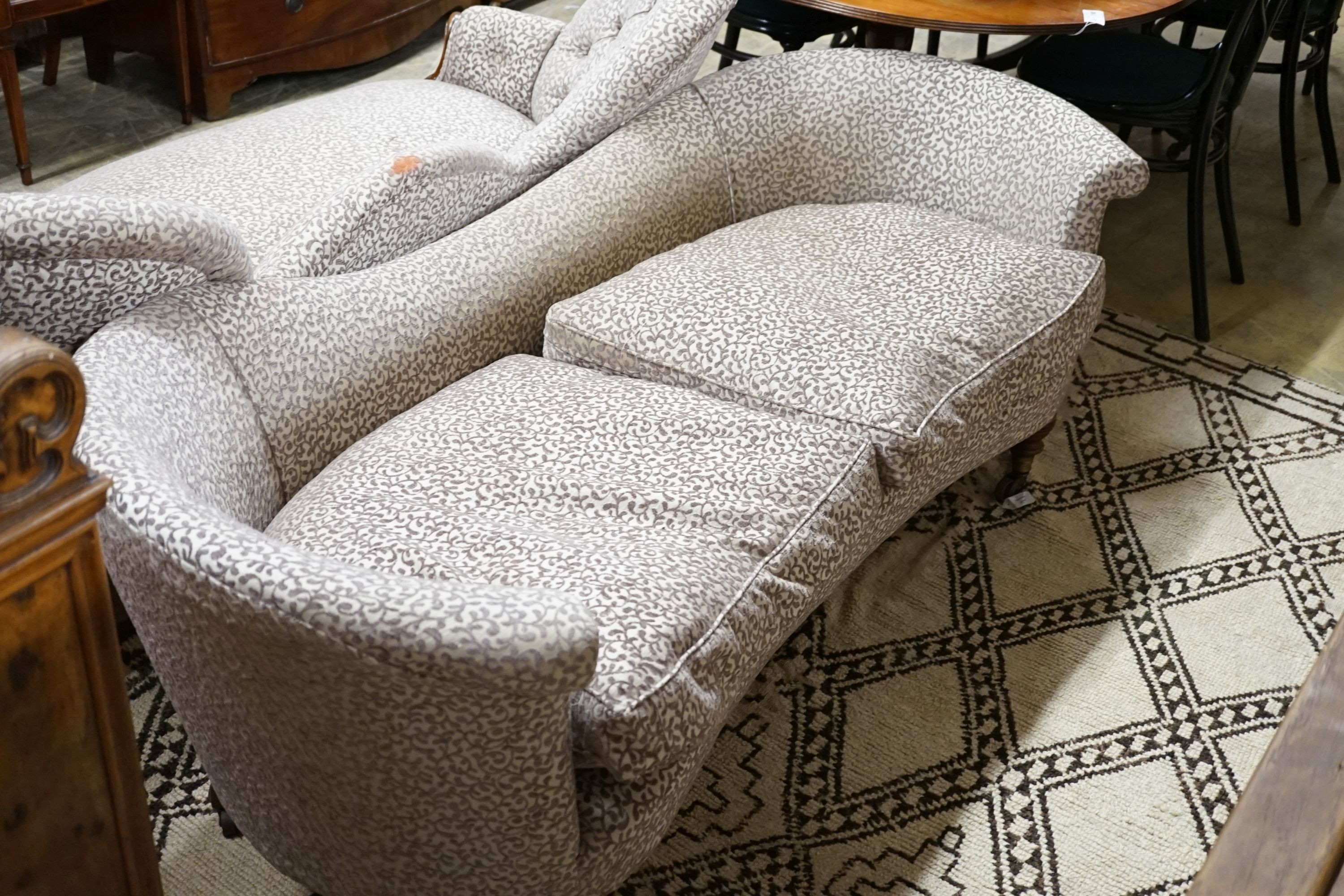 A Victorian upholstered settee with turned walnut legs, fitted brass castors, length 188cm